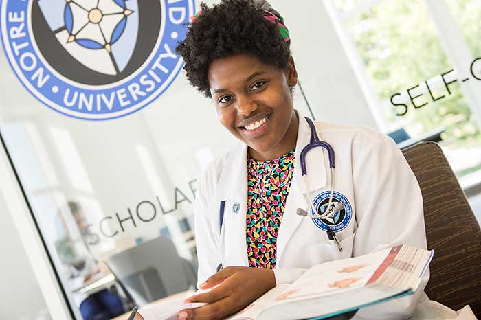 NDMU nursing student with textbook