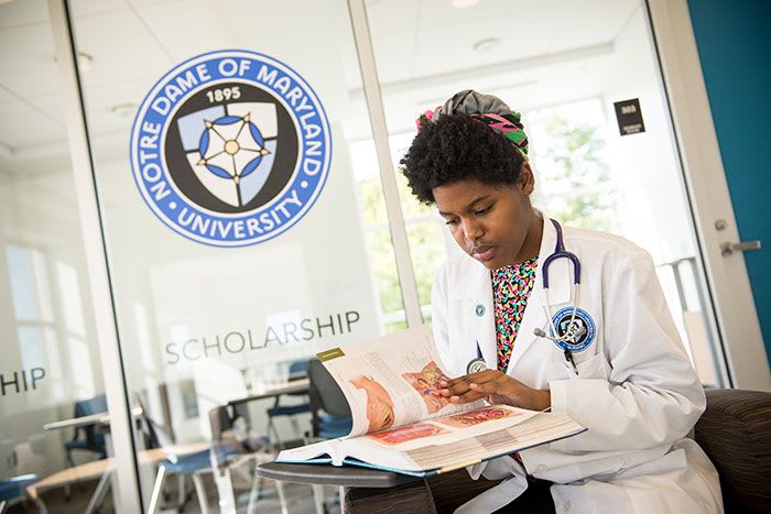 NDMU nursing student studying with nursing textbook