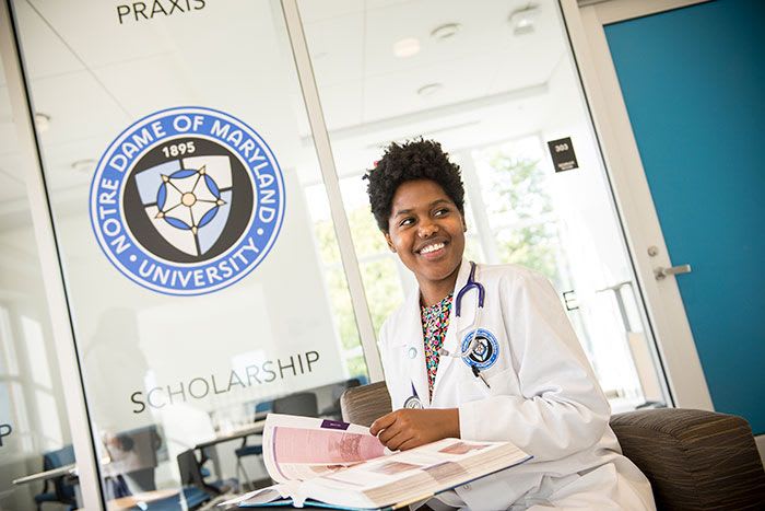 NDMU nursing student with textbook