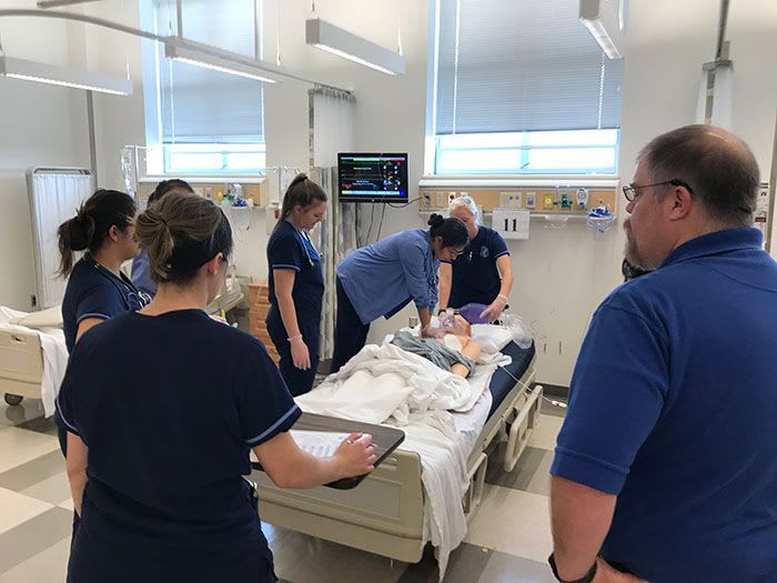 nursing students in simulation lab working with simulation manikin