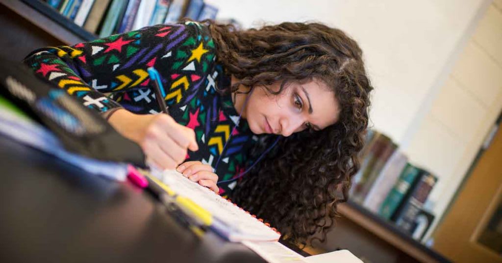 nursing student studying with textbook