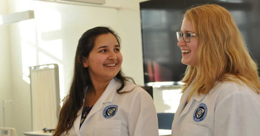 two nursing students in white lab coats