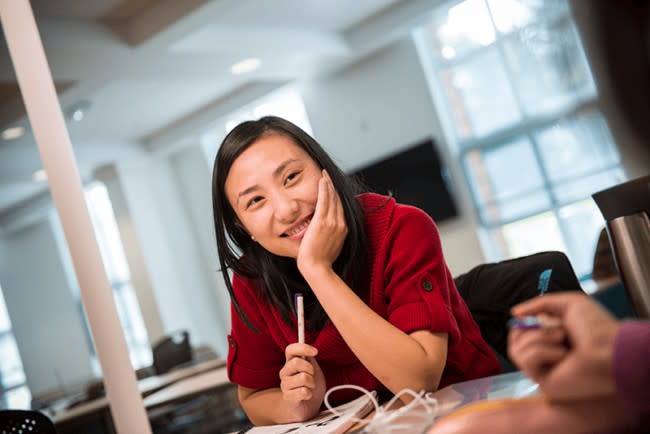 student smiling while studying with friend