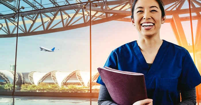 Smiling nurse in scrubs holding notebook