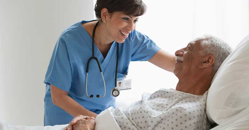 Nurse attending to patient in hospital bed