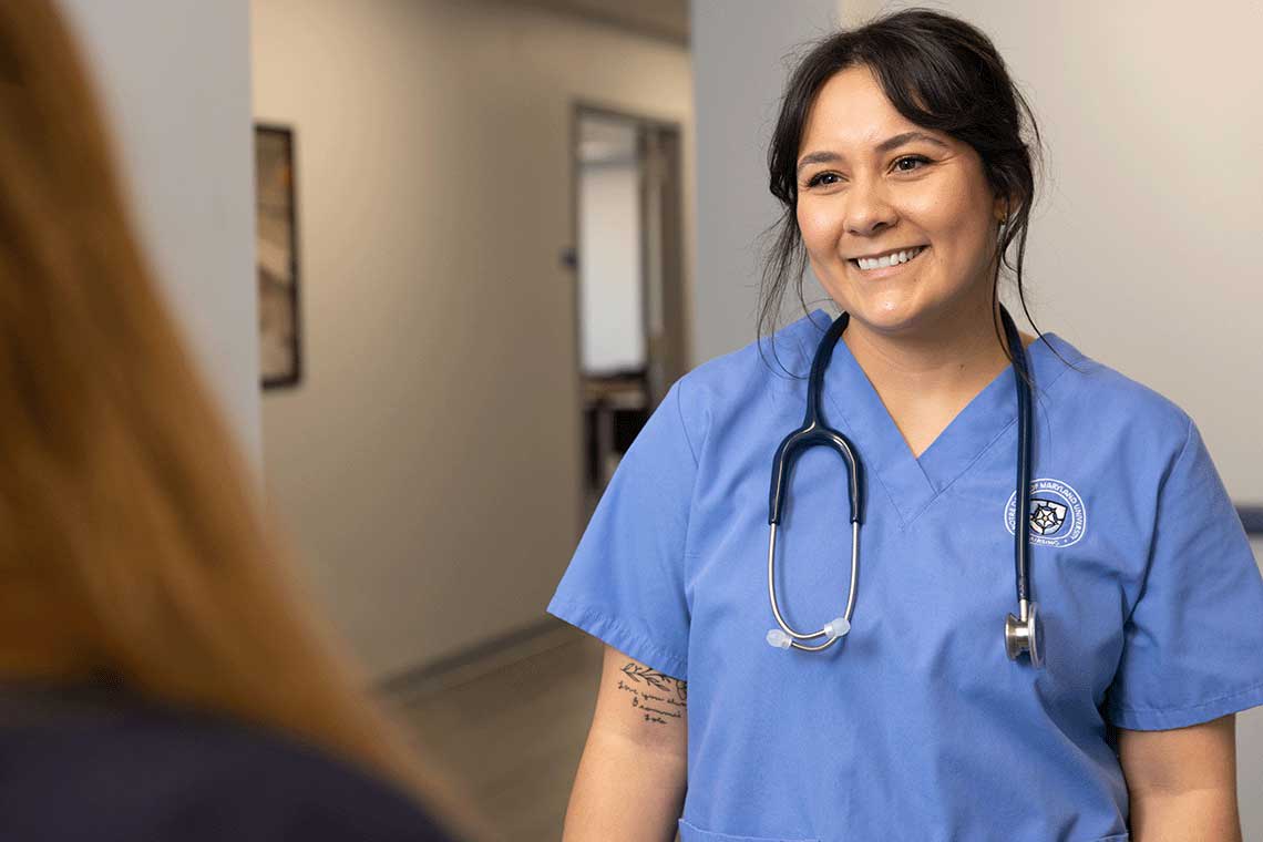 NDMU student wearing stethoscope and smiling