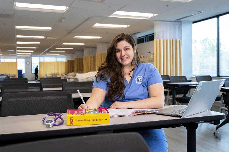 Nursing student sitting at desk working on computer