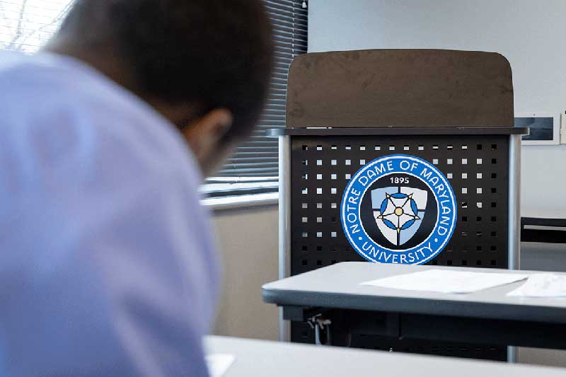 NDMU student sitting at desk