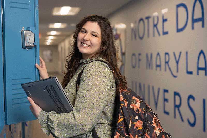 Nursing student smiling while at locker