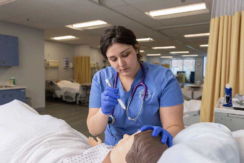 NDMU student working on a manikin