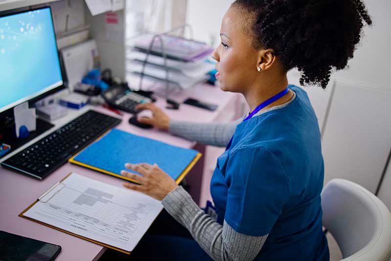 nurse at desk working on computer