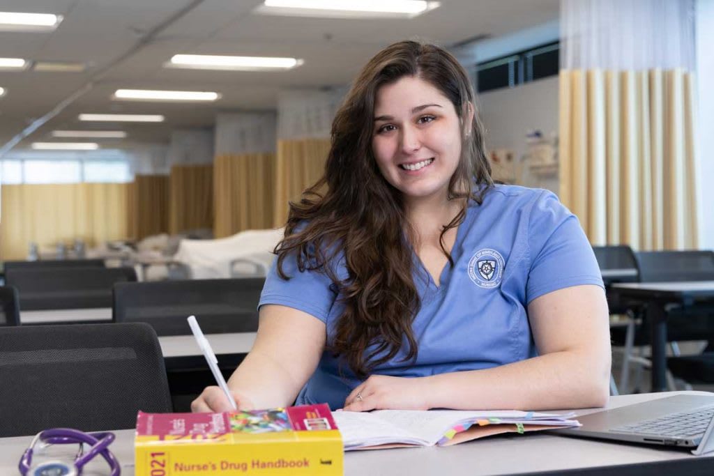 NDMU ABSN student sitting at desk studying