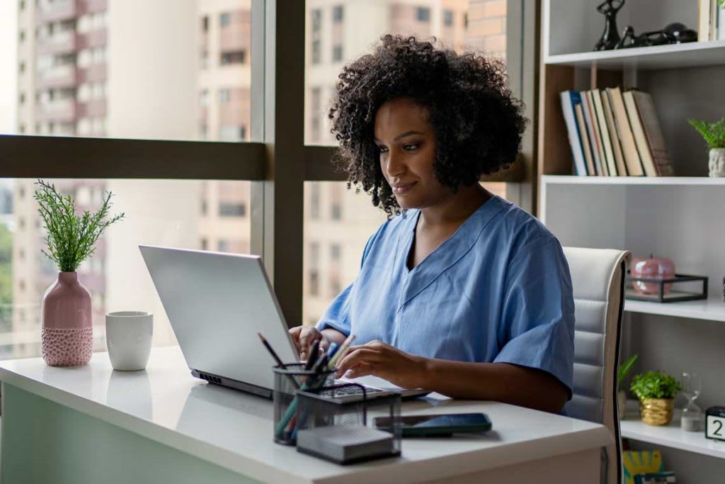 nurse sitting at desk using laptop