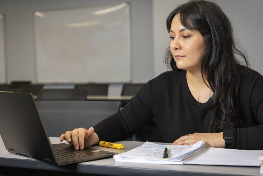 student with laptop and books