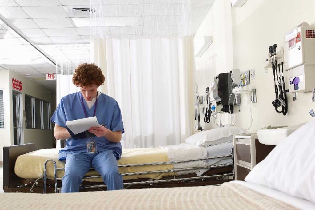 nurse sitting on hospital bed