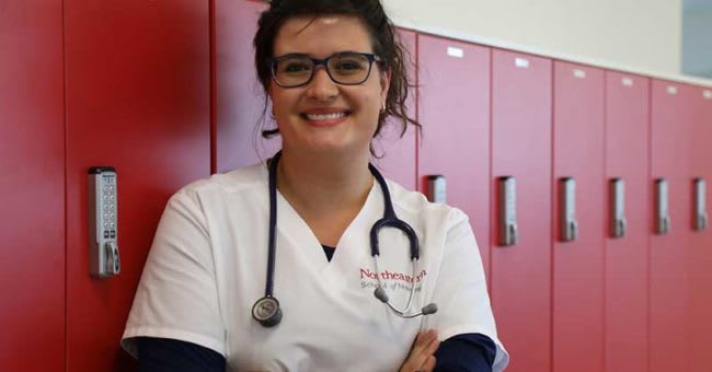 Northeastern BSN student standing by lockers smiling