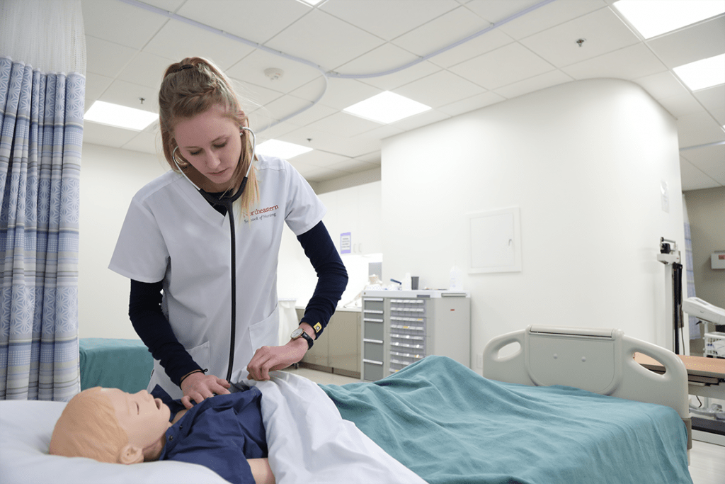 Northeastern nursing student working on sim manikin