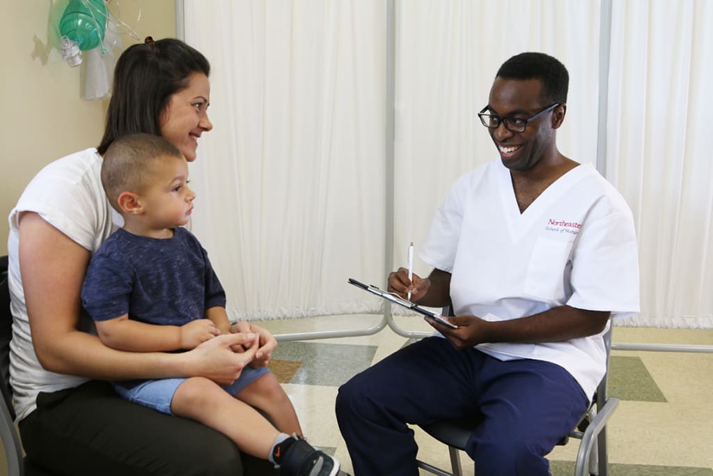 Northeastern ABSN student sitting with patients