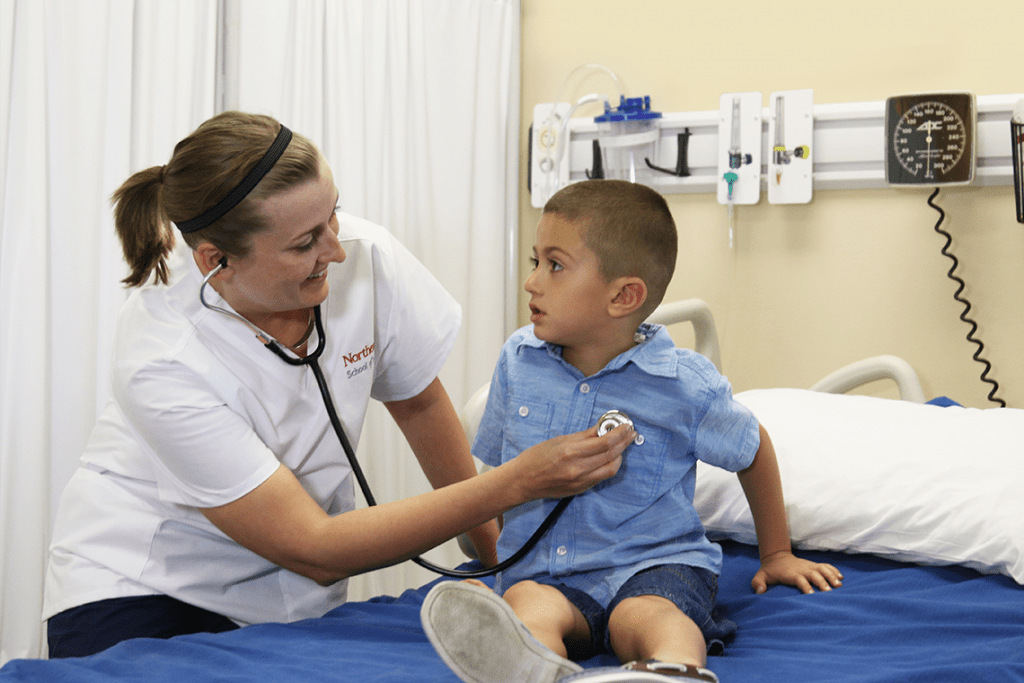 Northeastern ABSN student listening to child's heartbeat