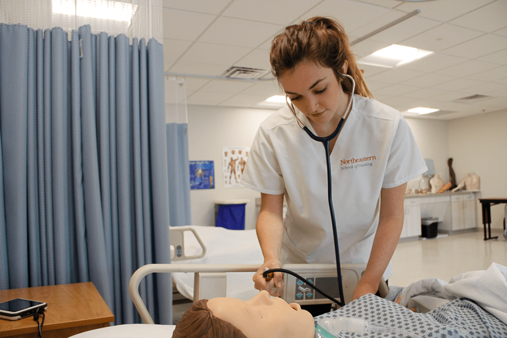 Northeastern ABSN student working with sim manikin