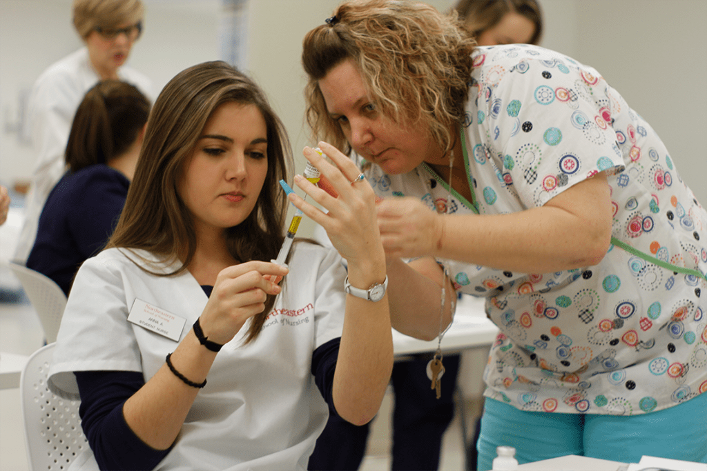 Northeastern nursing student practicing with lab equipment