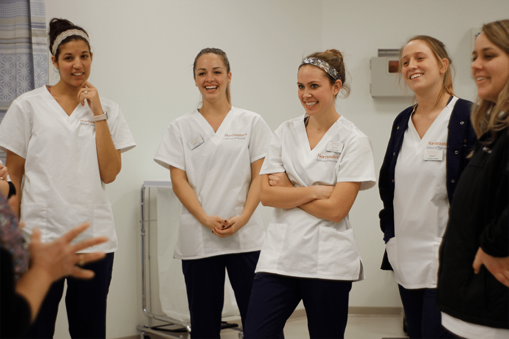 Northeastern nursing students standing in room smiling