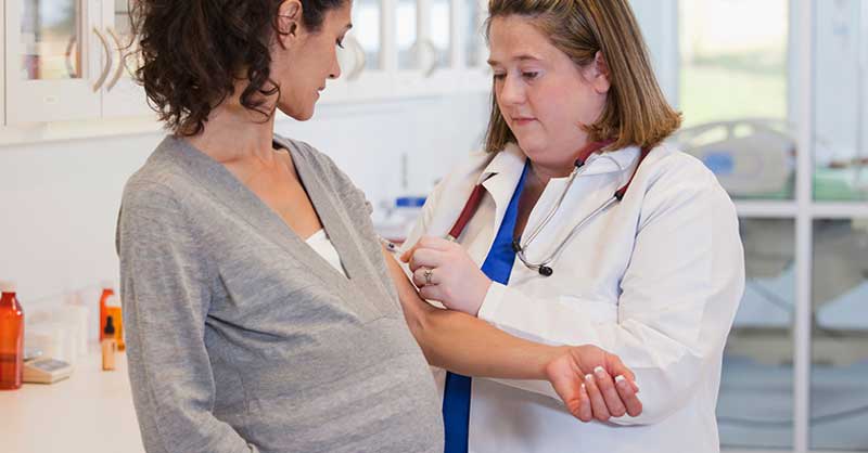 Nurse helping patient with arm