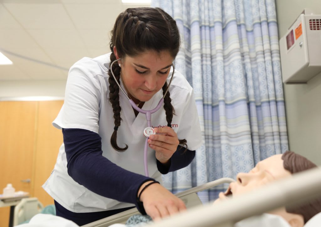 Northeastern nursing student working with sim manikin