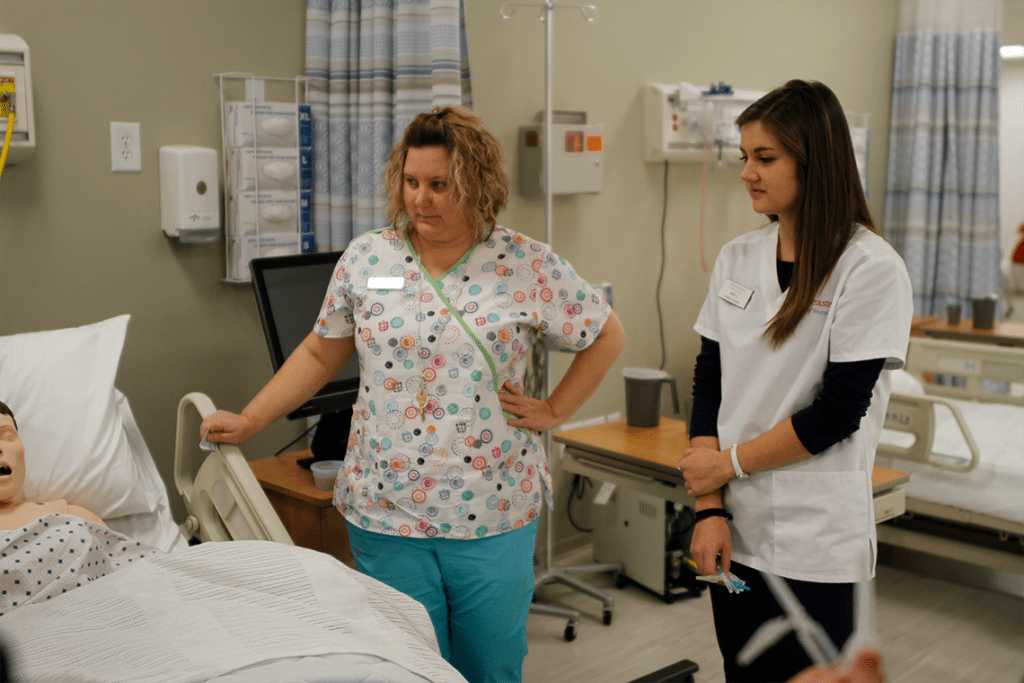 two nursing students standing in lab