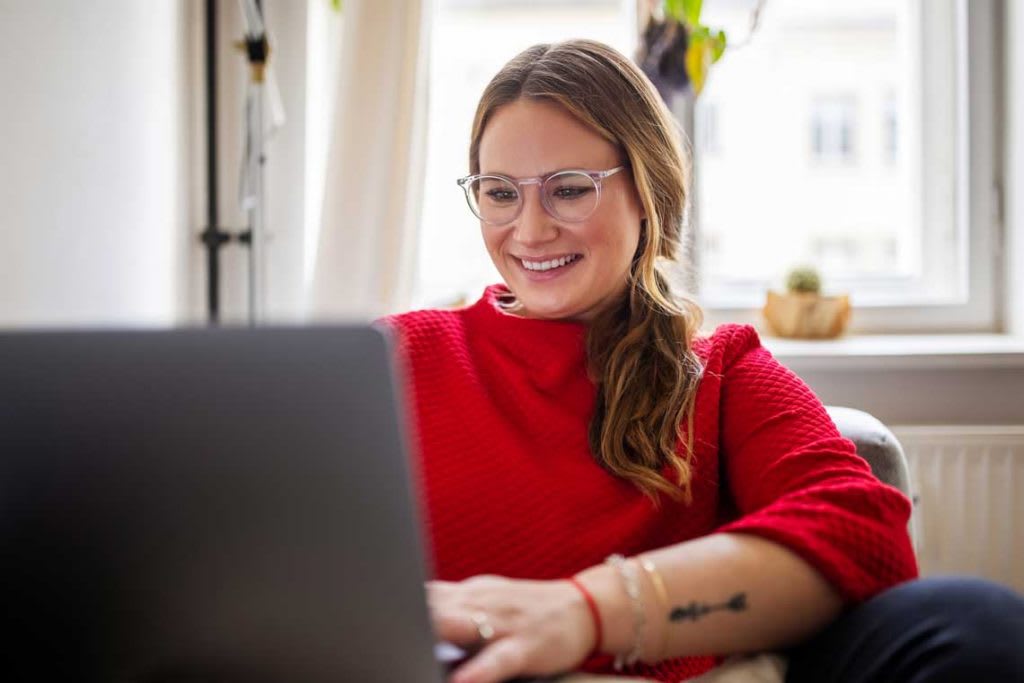 woman sitting at desk typing on a computer