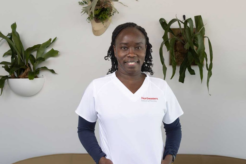 Northeastern nursing student standing in hall smiling