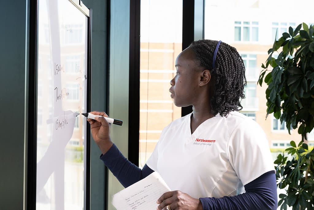 nursing student working on whiteboard