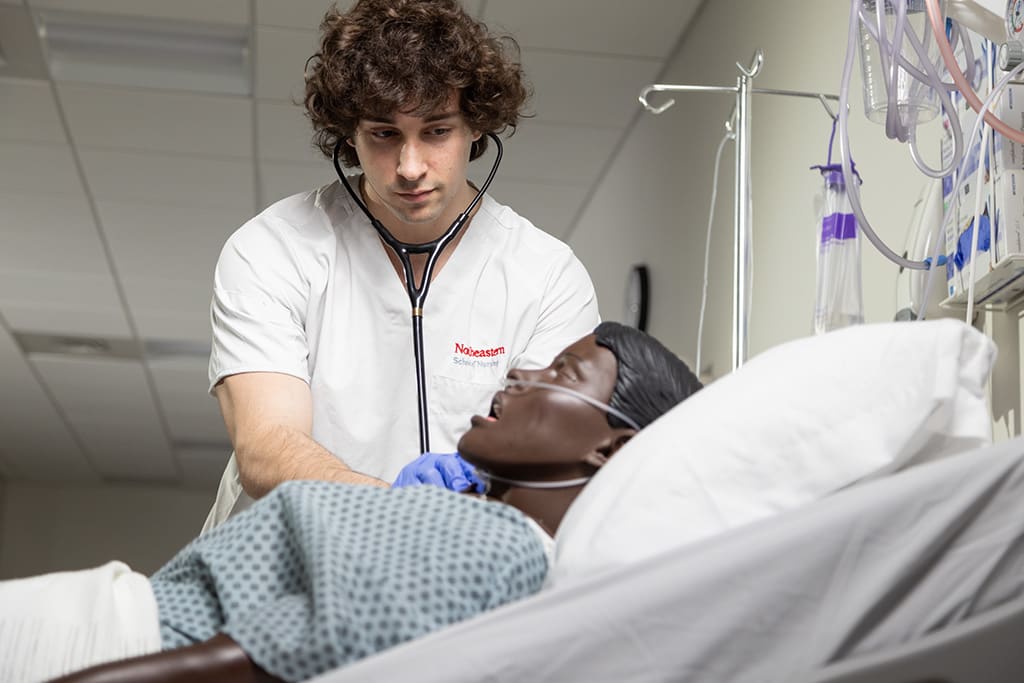 northeastern nursing student practicing on manikin with sethoscope