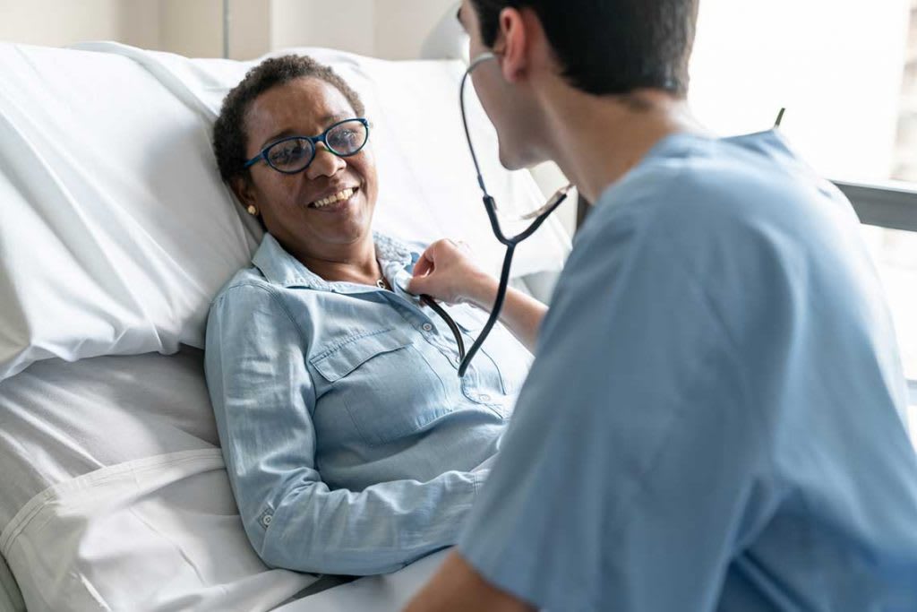 nurse listening to patient's heartbeat