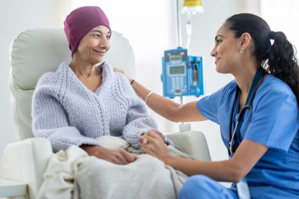 nurse sitting next to cancer patient