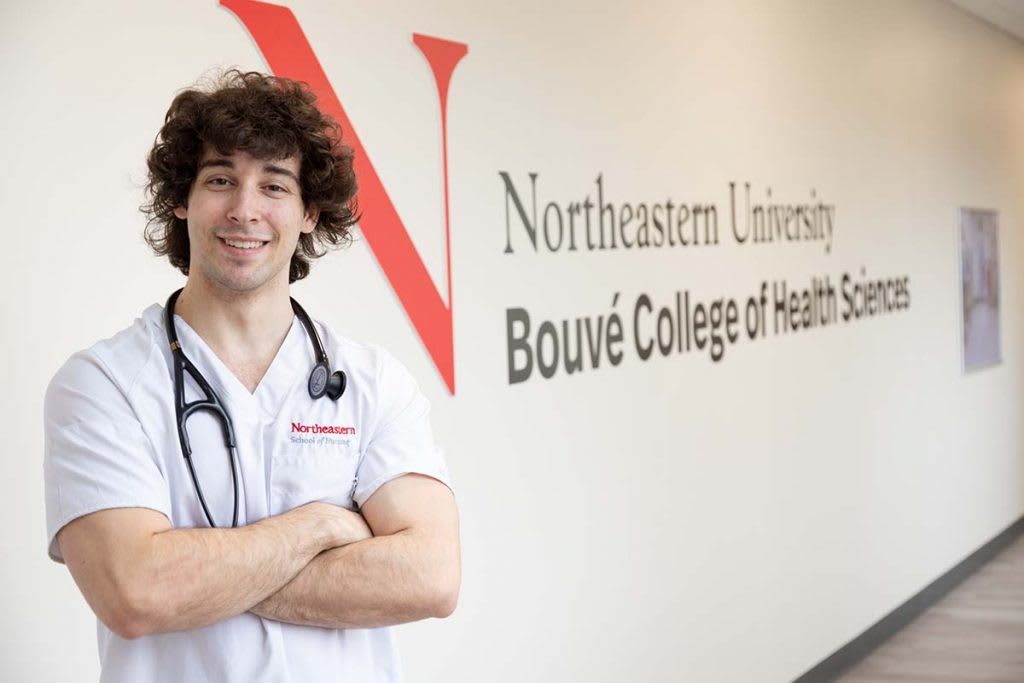 student in front of sign