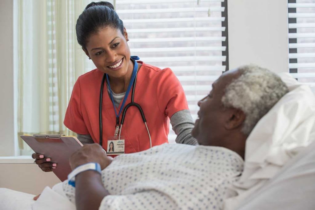 nurse in red scrubs with patient