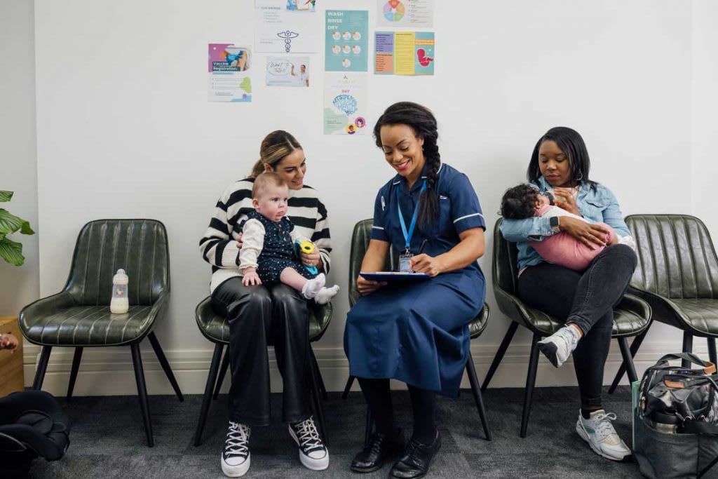 nurse speaks to mother in clinic