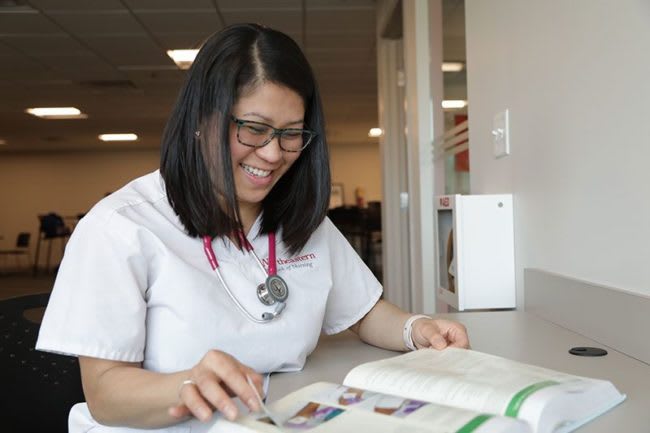 Northeastern University ABSN student studying with text book