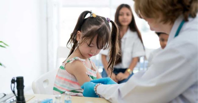 Nurse giving child patient a band-aid