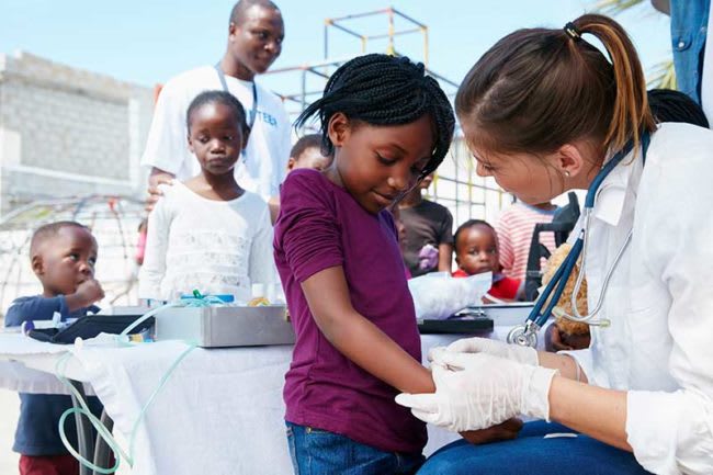 nurse helping child with band-aid