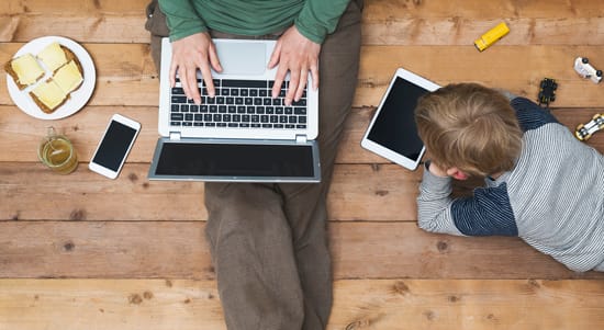 woman on laptop with child using tablet