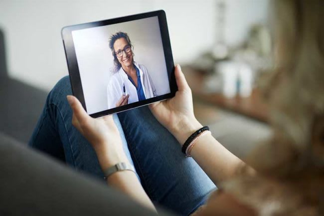 person holding tablet with nurse on virtual call