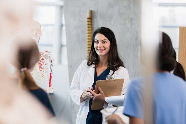 nurse standing holding clipboard