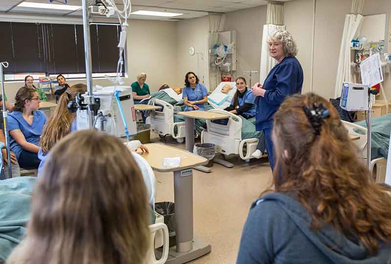 nursing students in lab with instructor