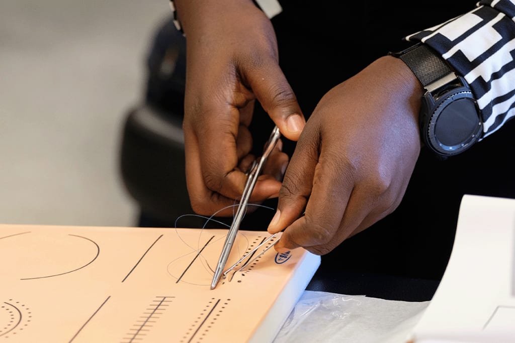 student practicing suturing