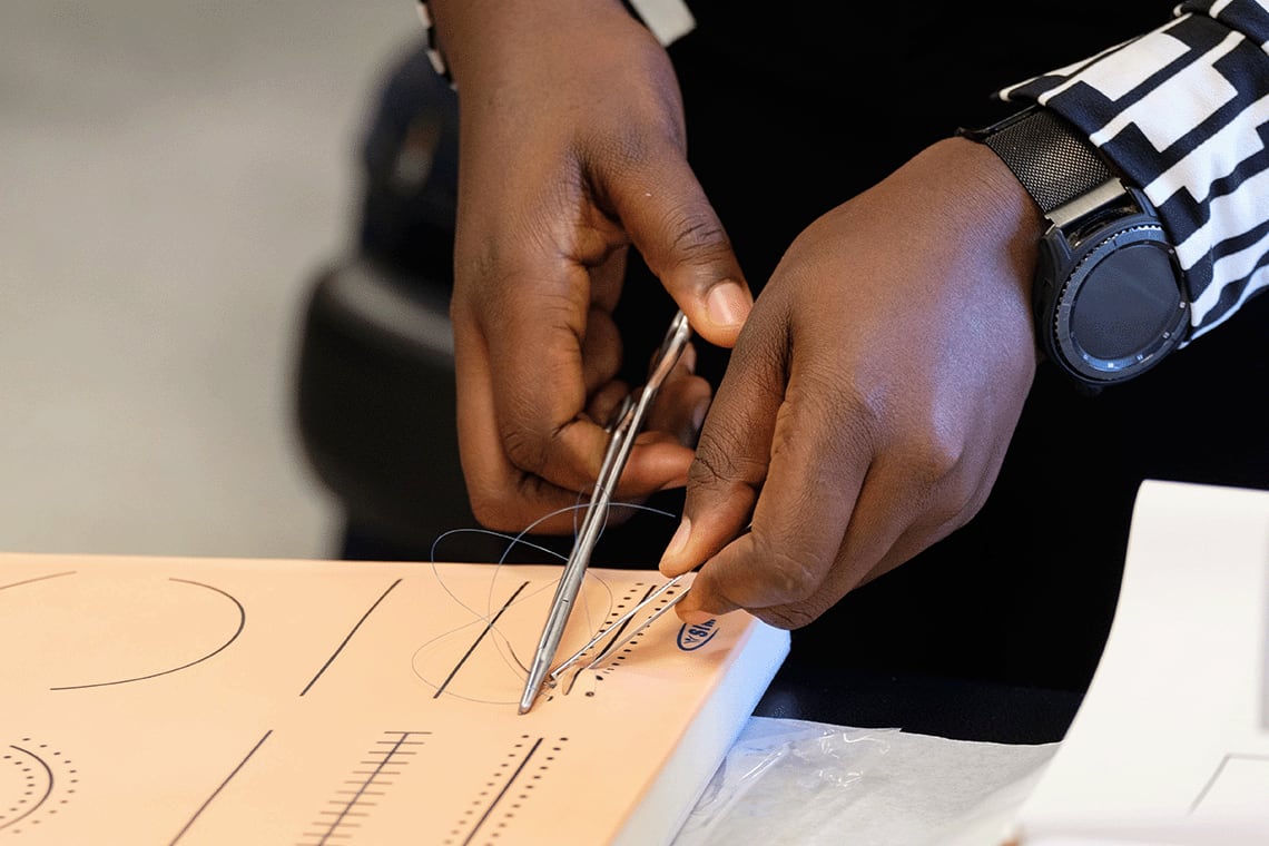 student practicing suturing