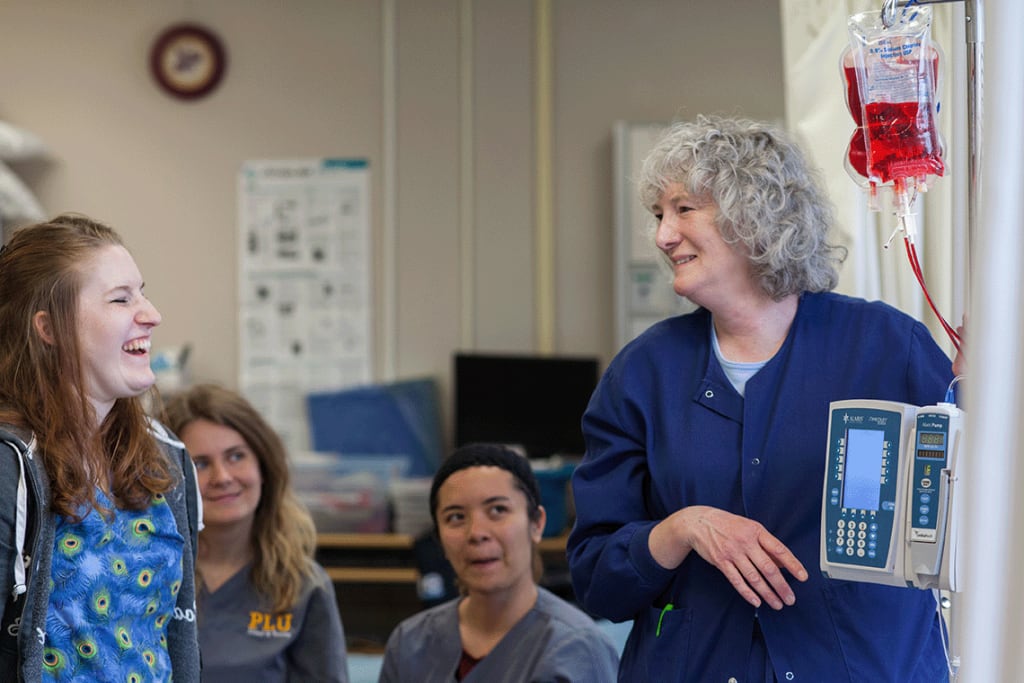 nursing instructor laughing with nursing students