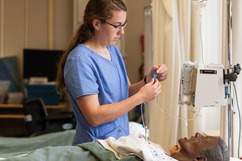 nursing student in lab working with IV