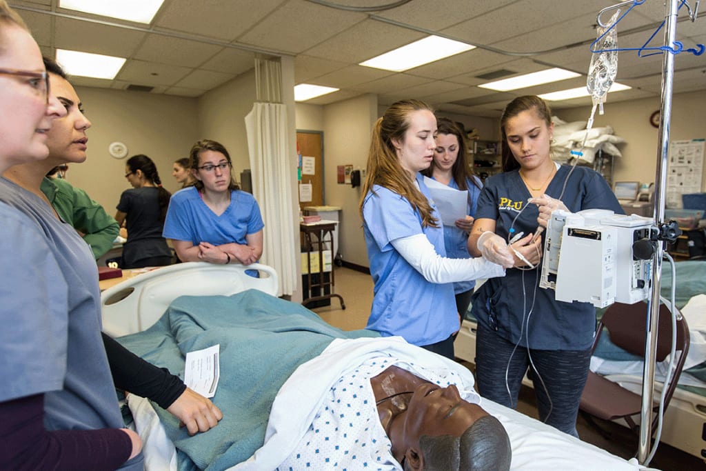 PLU nursing students working with lab equipment